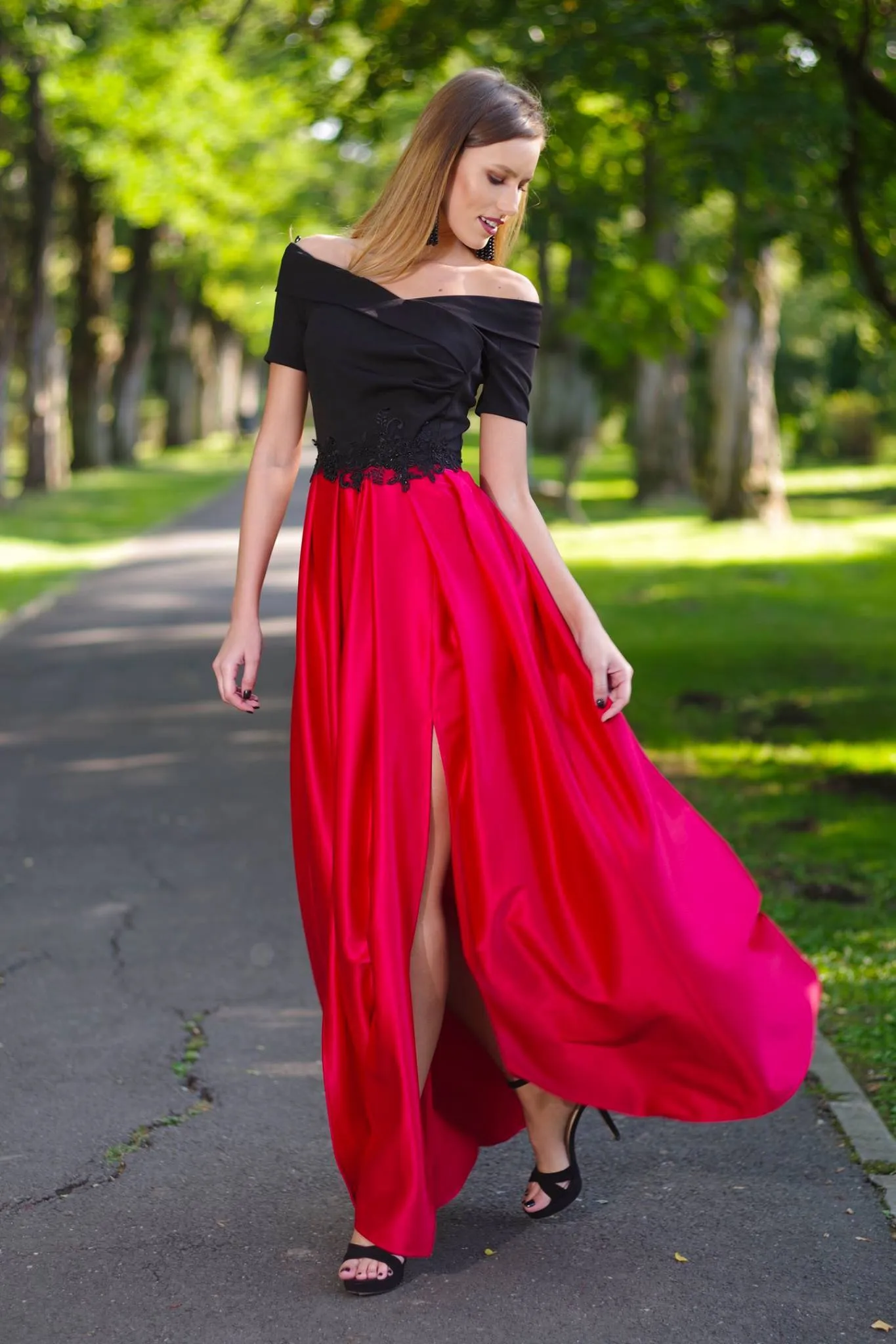 Black bodice artist long dress with red flared skirt and embroidered waist.