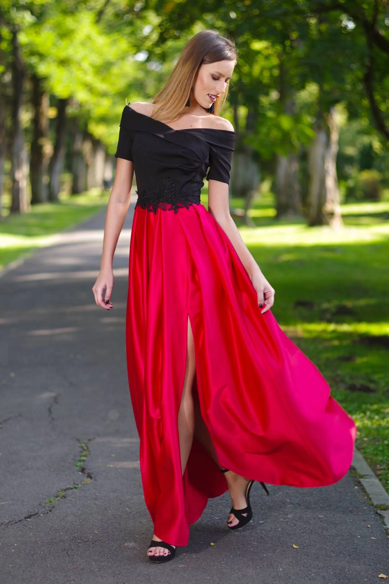 Black bodice artist long dress with red flared skirt and embroidered waist.