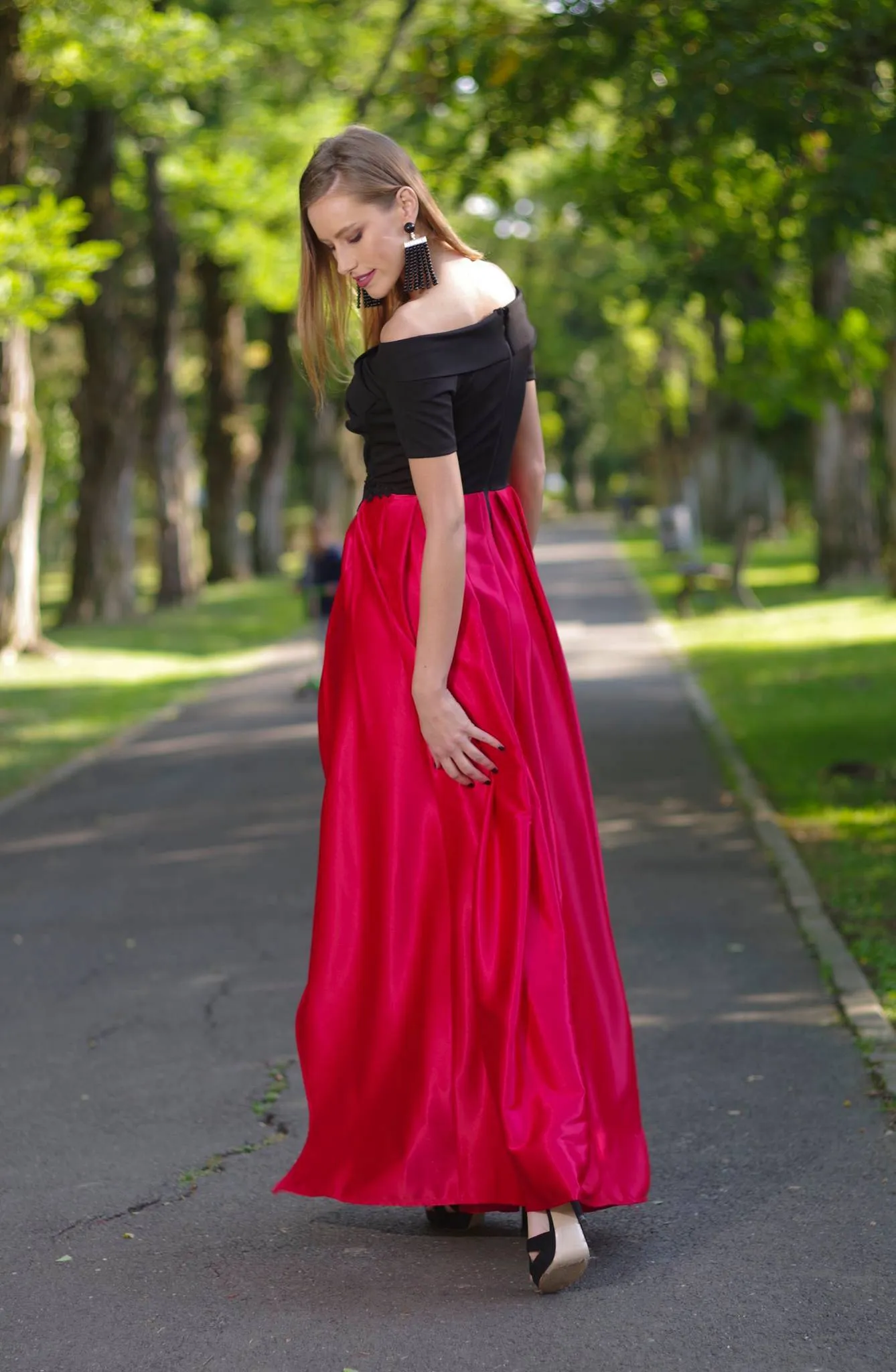 Black bodice artist long dress with red flared skirt and embroidered waist.